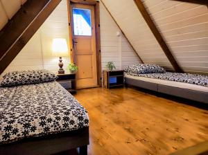 a attic room with two beds and a window at Wypoczynek "POD BRZÓSTKAMI" in Nagłowice