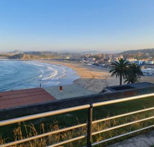 a view of a beach with palm trees and the ocean at La Casita de Suances 1- Jardín y Parking, Ideal Familias y Mascotas in Suances
