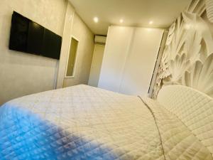 a bedroom with a bed and a flat screen tv at Hope House in Villasimius