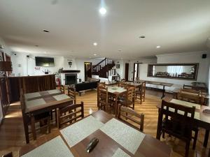 a restaurant with wooden tables and wooden chairs at Pousada Pinheiro Real in Campos do Jordão