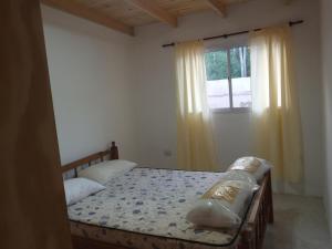 ネコチェアにあるDepartamento Necochea para 4のベッドとカーテンのついた窓のある寝室