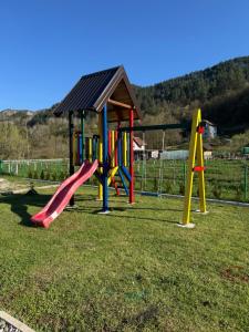 a playground with colorful play equipment in a field at Vikendica sa bazenom MAGNUM in Višegrad