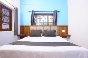 a bedroom with a large white bed with a window at Hotel Amardeep in Calangute