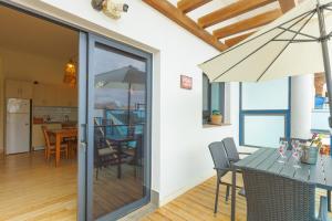 a kitchen and dining room with a table and an umbrella at Cotillo Jolanda in Cotillo
