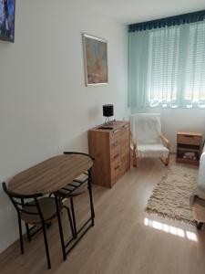 a living room with a table and a chair at City-Garzon in Kaposvár