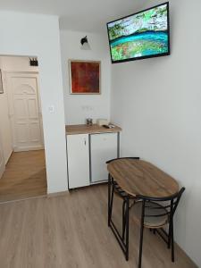 a table and chair in a room with a desk at City-Garzon in Kaposvár