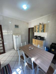 a kitchen with a table and chairs in a room at Casa a 2 minutos do santuário Nossa Senhora aparecida in Aparecida