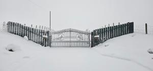 a fence covered in snow in a yard at Auchenhill Lodge in Denny