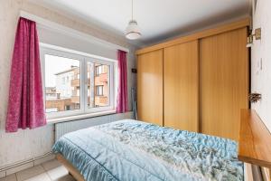 ein Schlafzimmer mit einem Bett und einem Fenster in der Unterkunft Jackylène 0401 in Koksijde