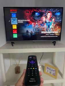 TV a/nebo společenská místnost v ubytování Quarto próximo ao Aeroporto Internacional