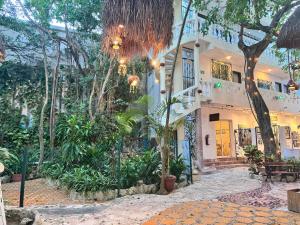 Un edificio con árboles y plantas delante. en Hotel Ha Garden Gallery - 5th Avenue, en Playa del Carmen