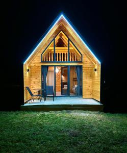 a wooden cabin with a table and chairs in the dark at Eternum Glamping in Žabljak