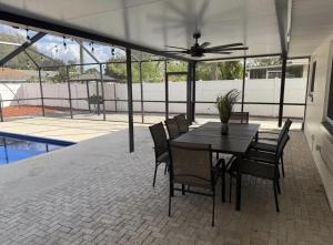 a patio with a table and chairs and a ceiling fan at 5 BR home with pool and outdoor fun in Winter Haven