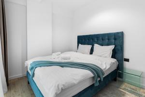 a bed with a blue headboard in a room at Exotic Sunrise View in Infinity Pool & Spa Resort in Mamaia Sat/Năvodari