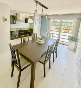 a kitchen and dining room with a table and chairs at Chalet adosado a escasos metros de la playa - Villa Arena in Alcossebre