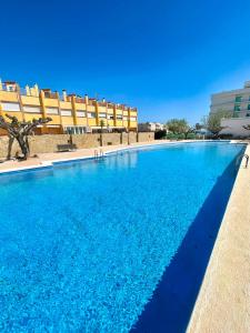 a large blue swimming pool in front of a building at Chalet adosado a escasos metros de la playa - Villa Arena in Alcossebre