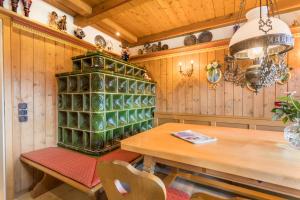 a dining room with a table and a shelf of green glassware at Ferienhaus am Hochgern in Unterwössen