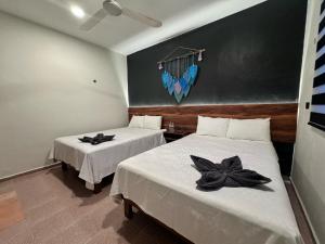 1 dormitorio con 2 camas con flores negras en Hotel Ha Garden Gallery - 5th Avenue, en Playa del Carmen