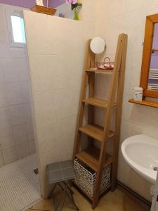 a wooden shelf in a bathroom with a sink at Cottage le petit Tôt in Barneville-Carteret