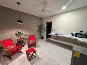 sala de estar con 2 sillas rojas y barra en Hotel Ha Garden Gallery - 5th Avenue, en Playa del Carmen