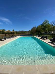 a large swimming pool with blue water at Camping LE MOULIN DE CAUDON in Domme