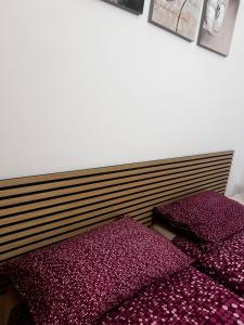 two beds in a room with purple pillows at Casa Vacanze Fabrizio in Balestrate