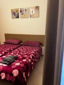 a bedroom with two beds with pink comforter at Casa Vacanze Fabrizio in Balestrate