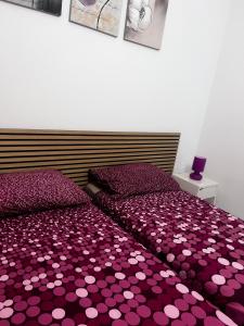 a bedroom with a purple bedspread with hearts on it at Casa Vacanze Fabrizio in Balestrate