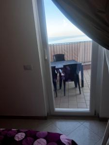 a room with a table and a view of a balcony at Casa Vacanze Fabrizio in Balestrate