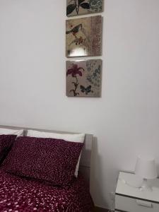 a bedroom with a bed and three pictures on the wall at Casa Vacanze Fabrizio in Balestrate +12 photos