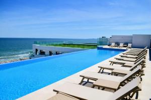 a swimming pool with lounge chairs and the ocean at Exotic Sunrise View in Infinity Pool & Spa Resort in Mamaia Sat/Năvodari +75 photos