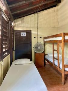 a bedroom with two bunk beds and a fan at OeNic! Hostal in Poneloya