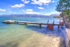 ein Dock auf einem See mit zwei Bänken im Wasser in der Unterkunft CYH1281- Tahoe Acres home in South Lake Tahoe + 64 Fotos