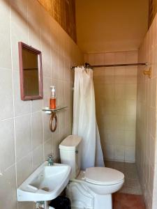 a bathroom with a toilet and a sink at OeNic! Hostal in Poneloya +25 photos
