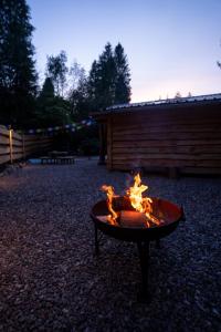 a fire pit in the middle of a yard at The Happy Cabin Woodland Hideaway by the River in Banavie