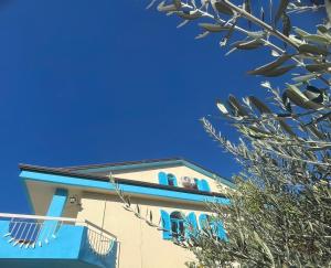 un edificio con finestre blu e un albero di Residence Quedar a Melfi