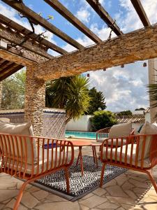 a patio with chairs and a table and a pool at La Closerie in Laredorte