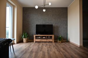 a living room with a flat screen tv on a wall at Apartament Podmiejska in Kalisz
