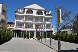 a large white building with flags in front of it at Villa Dislievski in Ohrid