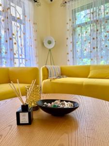 アルーシャにあるBurka Serene Homeのリビングルーム(黄色のソファ、テーブルの上に置かれたボウル付)