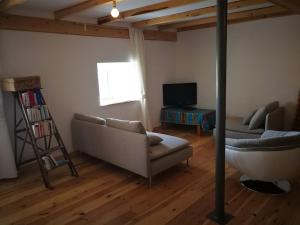 a living room with a couch and a television at Ferme traditionnelle in La Jarriage