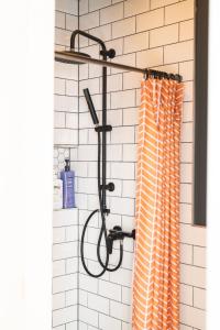 a shower with an orange shower curtain in a bathroom at Svencelė K-17 in Svencelė +26 photos