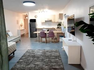 a kitchen and living room with a table and chairs at F2 Cookoon Toata Papeete in Papeete