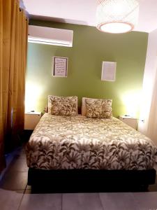 a bedroom with a bed in a green wall at F2 Cookoon Toata Papeete in Papeete +44 photos