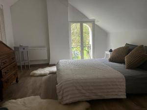 a bedroom with a large bed and a window at Altanca, Maison, calme au milieu de la nature près de Beauval, Chenonceau et autres chateaux de la Loire in Épeigné-les-Bois +42 photos