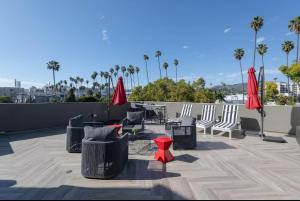 a patio with chairs and tables and umbrellas on a roof at Hollywood Cozy Apartment in Los Angeles +17 photos