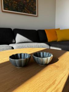 two metal bowls sitting on top of a wooden table at Bergpanorama in Sankt Gilgen