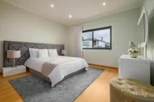 a bedroom with a large bed and a window at Cerrado da Eira, Vista Mar e Farol in Ponta Garça