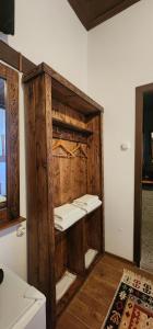 Habitación con una estantería de madera con sábanas blancas. en Silver Hill Guesthouse, en Gjirokastra 37 fotos más