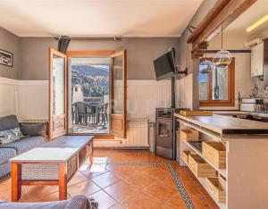 a kitchen and living room with a couch and a table at El capricho de Trevélez in Trevélez
